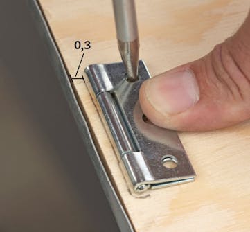 Lokket til putekasse settes fast Lokket til stor putekasse settes fast med bladhengsler